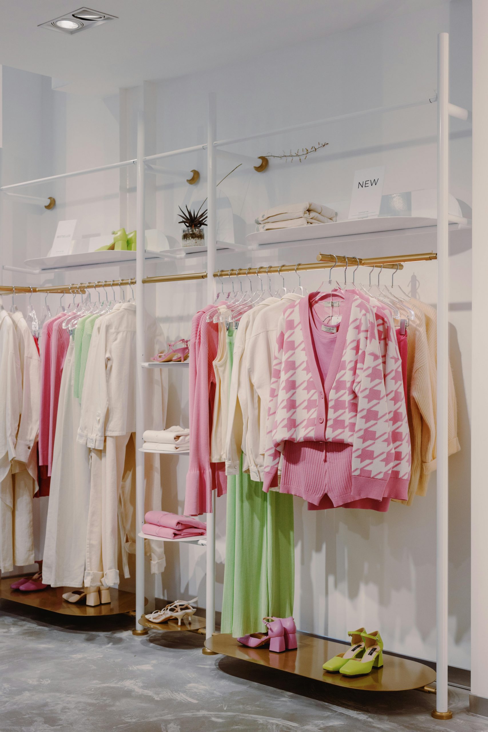 Stylish clothing display in modern boutique with colorful outfits and decor.